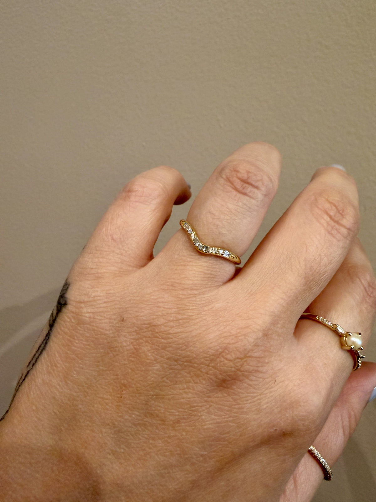 Jennie Kwon Diamond Staccato Wave Band with baguette and round diamonds in 14kt yellow gold worn on the hand