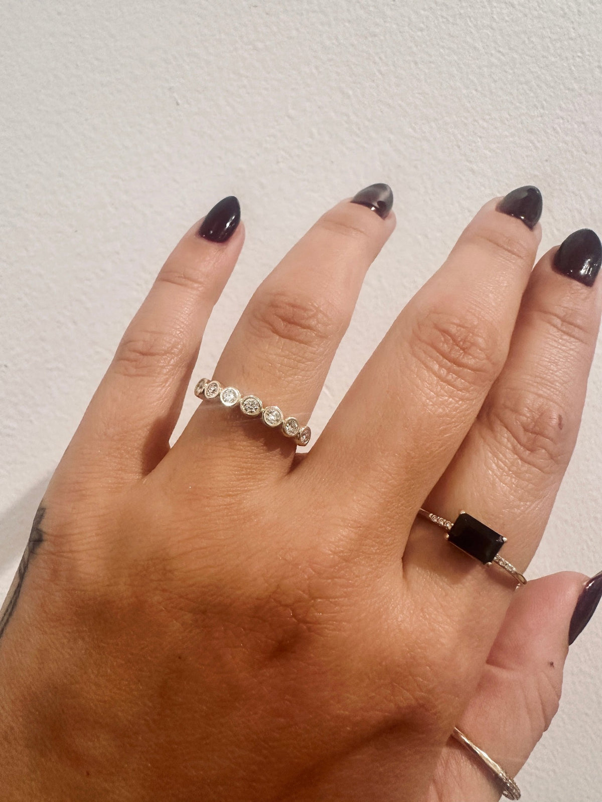 Diamond Deity wedding band in 14kt yellow gold with bezel set round diamonds worn on the hand