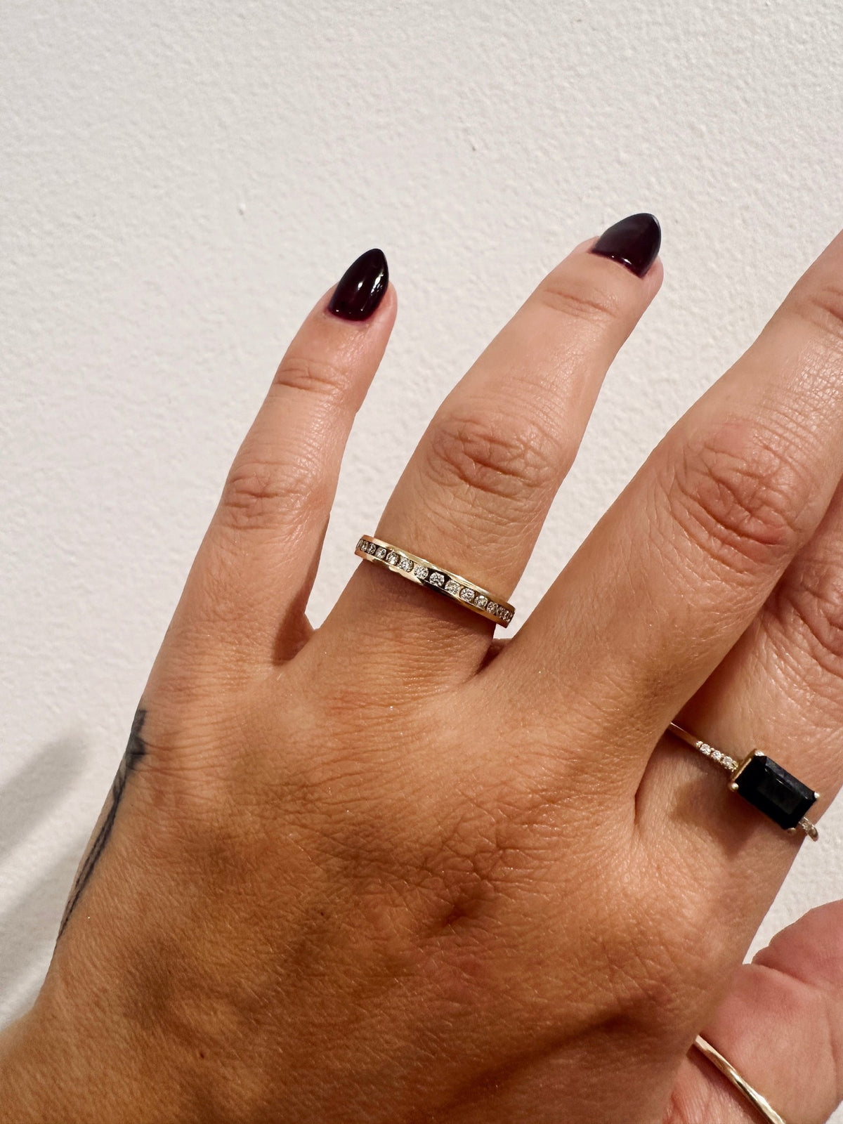 Channel Divina wedding band in 14kt yellow gold with channel set round diamonds worn on the hand