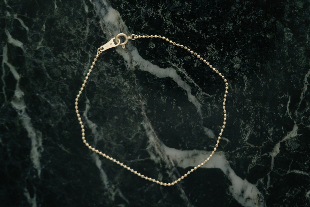BB Ball Chain Bracelet by Lane & Kate in gold, styled on green marble