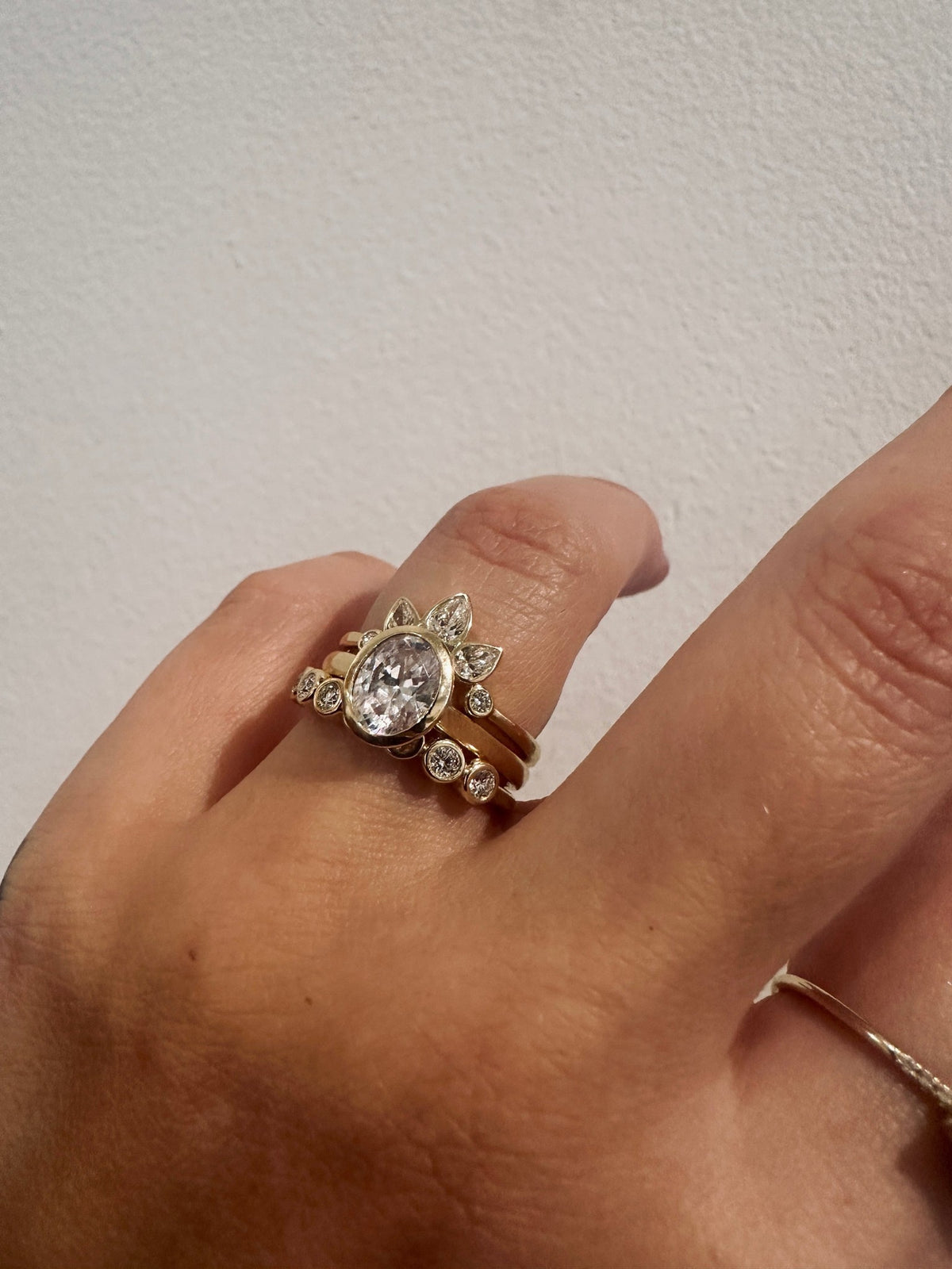 Diamond Deity wedding band in 14kt yellow gold with bezel set round diamonds worn on the hand
