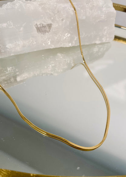 BB Herringbone Chain in 14kt yellow gold draped over selenite