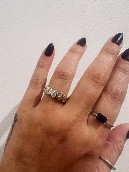 Oval Demur wedding band in 14kt yellow gold with bezel set oval diamonds worn on the hand