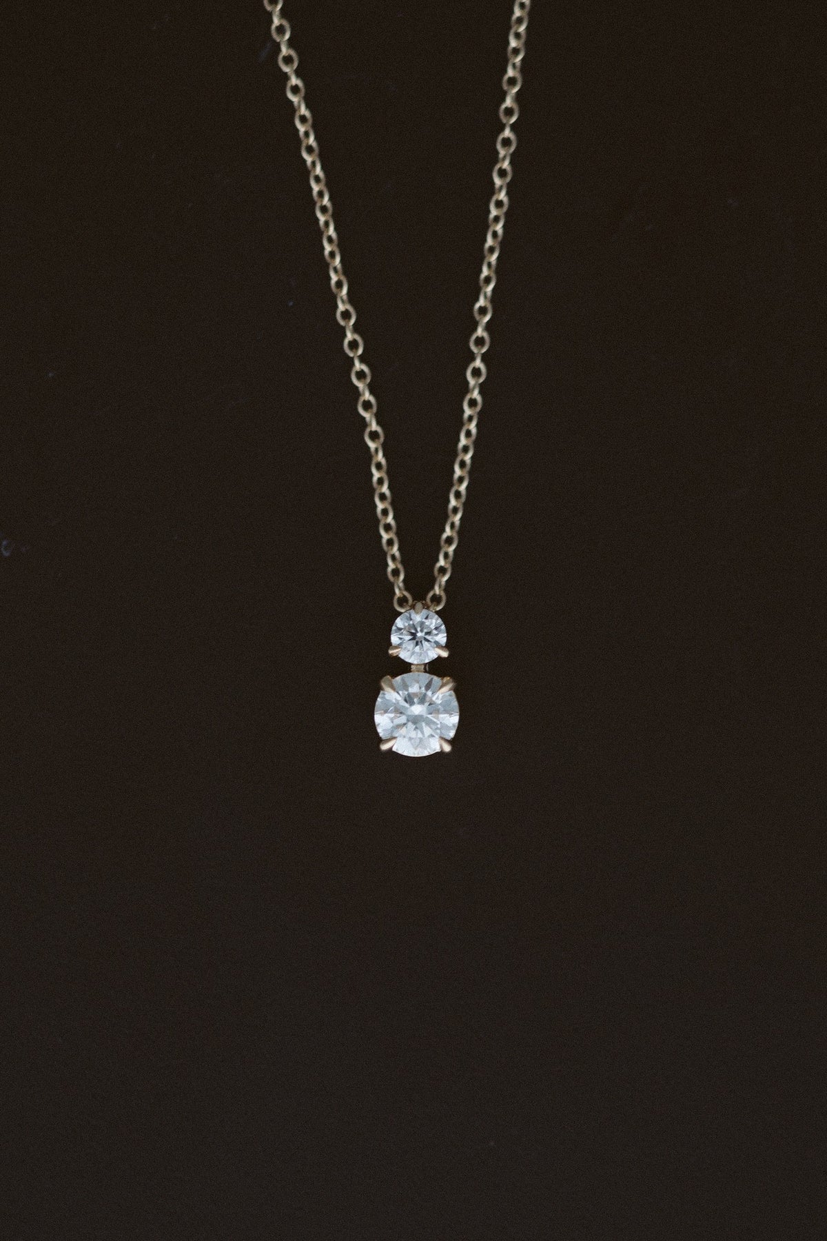 Diamond Horizon Pendant, two diamond necklace in 14kt yellow gold on a dark background