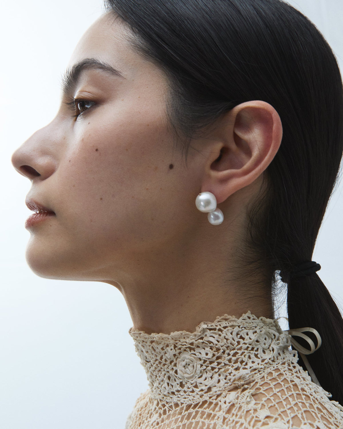 Pearl Clove Earrings worn on the ear, side profile