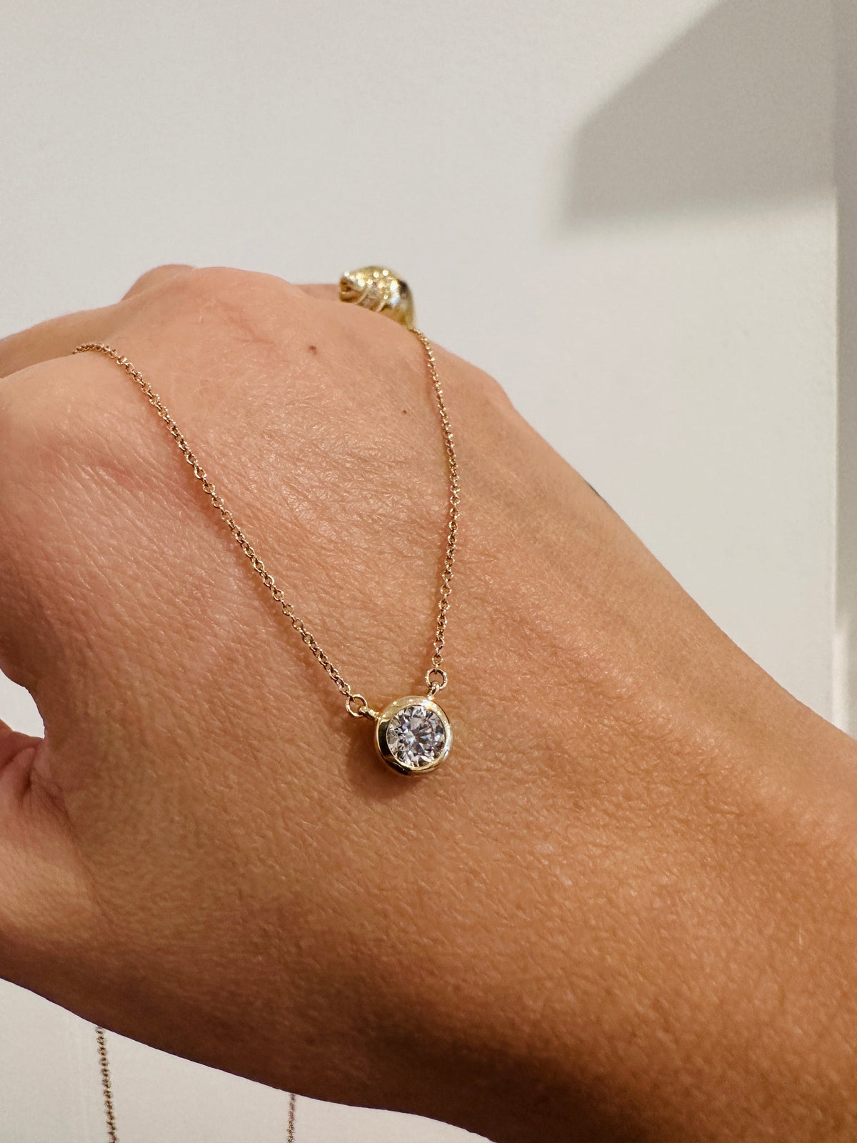 Heirloom Deity Pendant draped over the hand, close up