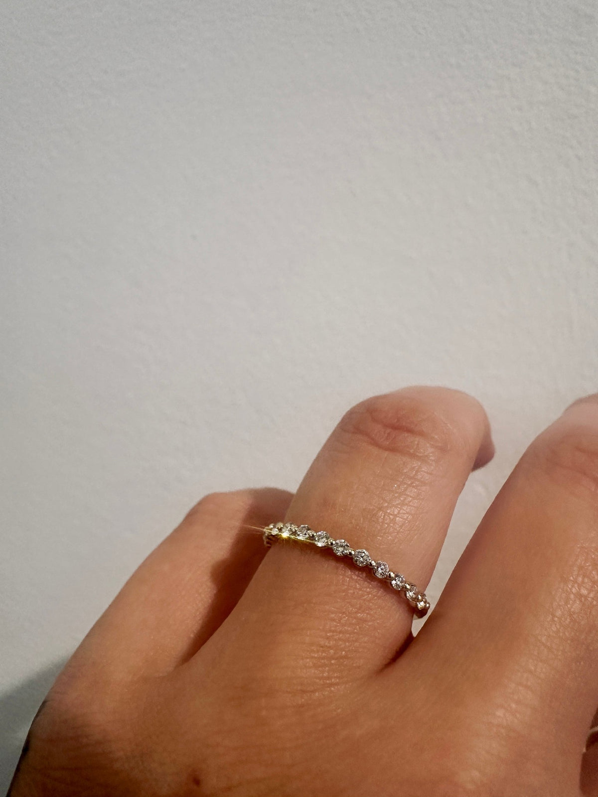 Diamond Dew wedding band in 14kt yellow gold with prong set round diamonds worn on the hand