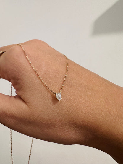 Tear of Cupid Pendant draped over the hand, close up