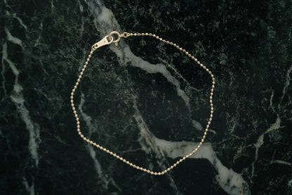 BB Ball Chain Bracelet by Lane &amp; Kate in gold, styled on green marble