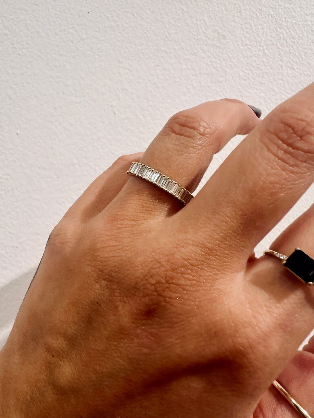 Baguette diamond cigar style wedding band close up on hand