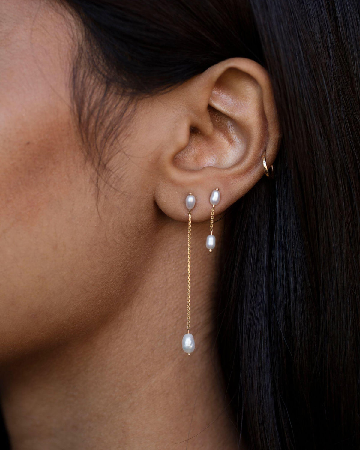 Long Pearl Shower Earrings worn in an ear stack