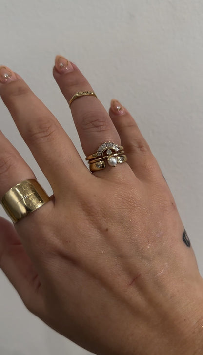 Baguette diamond contour band in a stack of gold rings on hand
