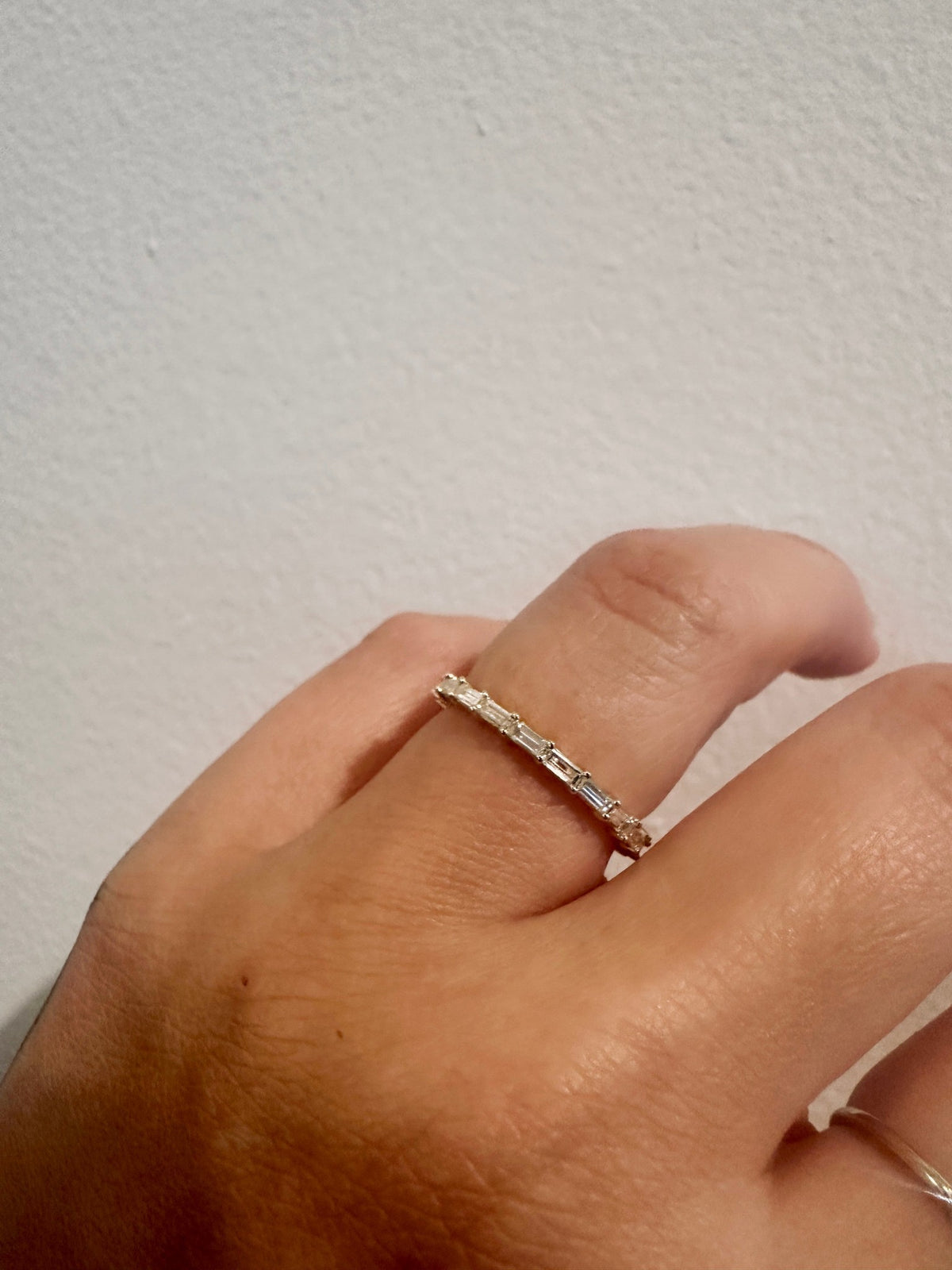 Baguette diamond wedding band in 14kt yellow gold close up on hand