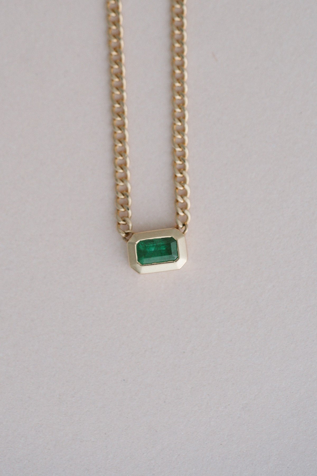Zoe Chicco Emerald Bezel Set Curb Chain, an emerald cut emerald in a gold bezel on blush
