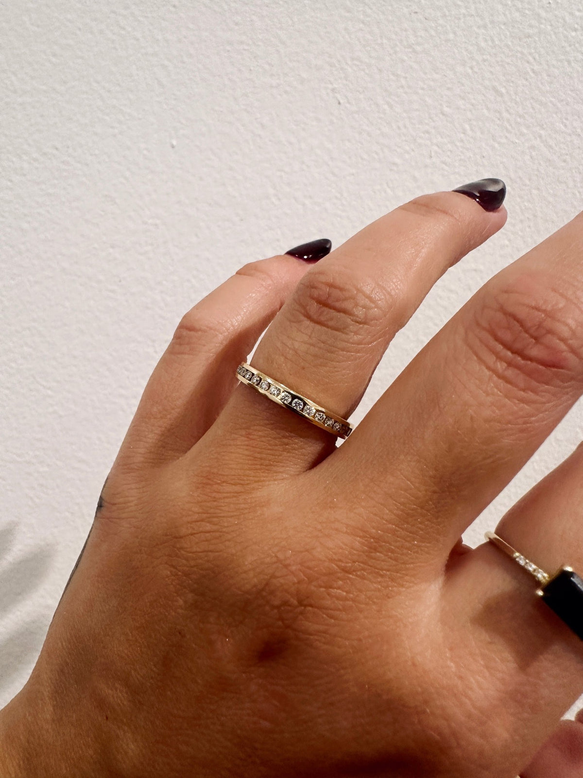 Channel Divina wedding band in 14kt yellow gold with channel set round diamonds worn on the hand