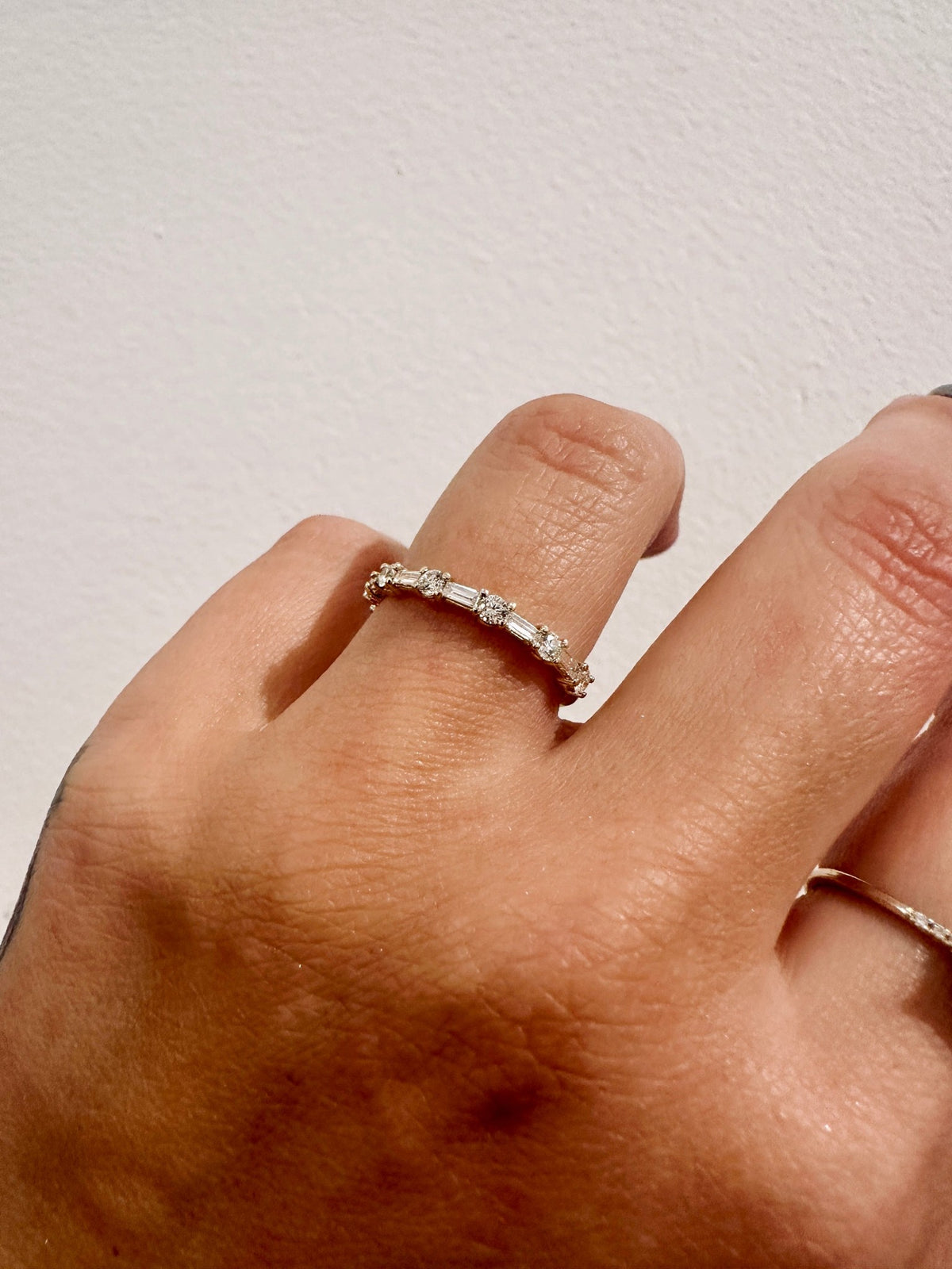 Cora Baguettes wedding band in 14kt yellow gold with baguette and round diamonds worn on the hand
