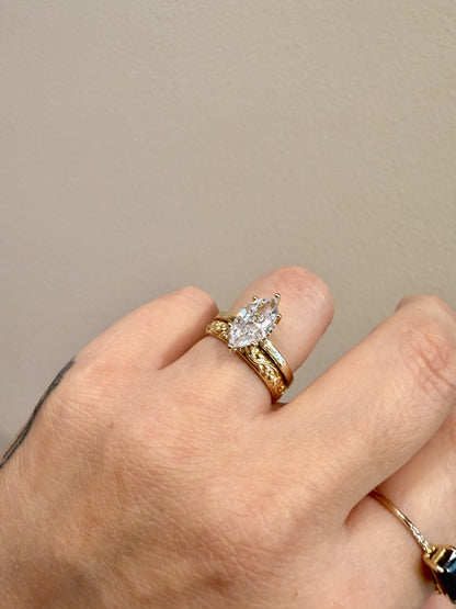 Golden Floral Band sculpted floral band in 14kt yellow gold paired with a marquise engagement ring