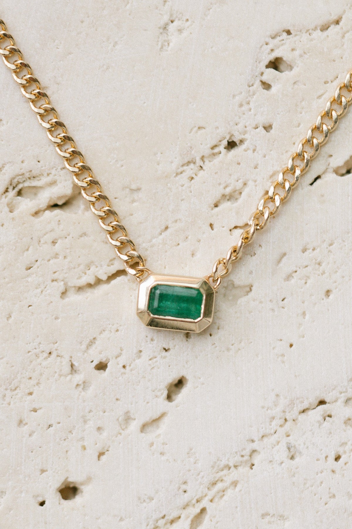 Zoe Chicco Emerald Bezel Set Curb Chain on travertine, close up of the emerald and curb links