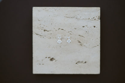 Horizon Diamond Earrings by Lane &amp; Kate, two stone diamond studs styled on travertine