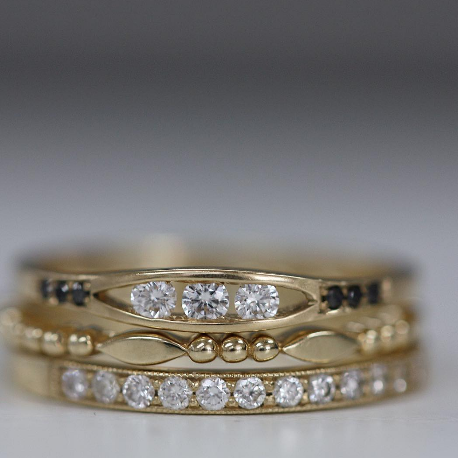 White &amp; Black Diamond Float Ring by Jennie Kwon, close up stacked with gold rings