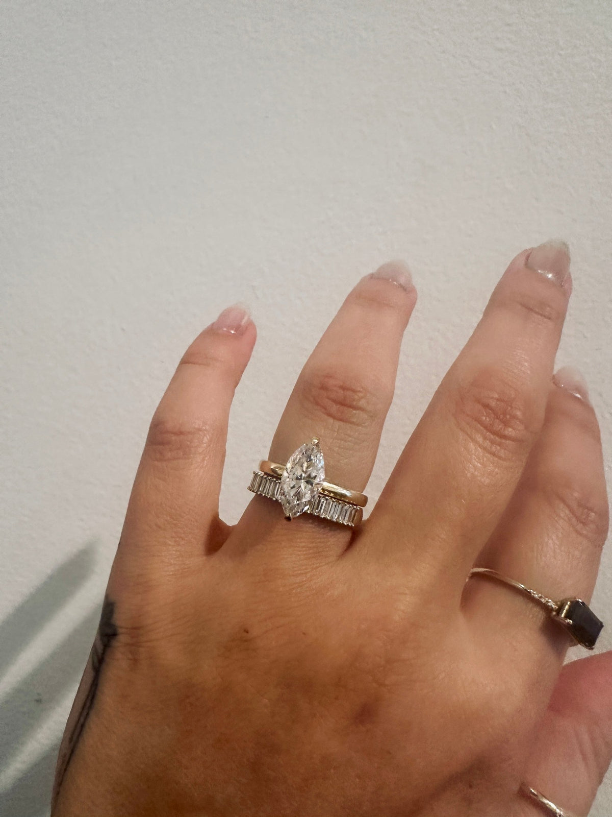 Baguette Incantations Wedding Band stacked with a pear diamond engagement ring