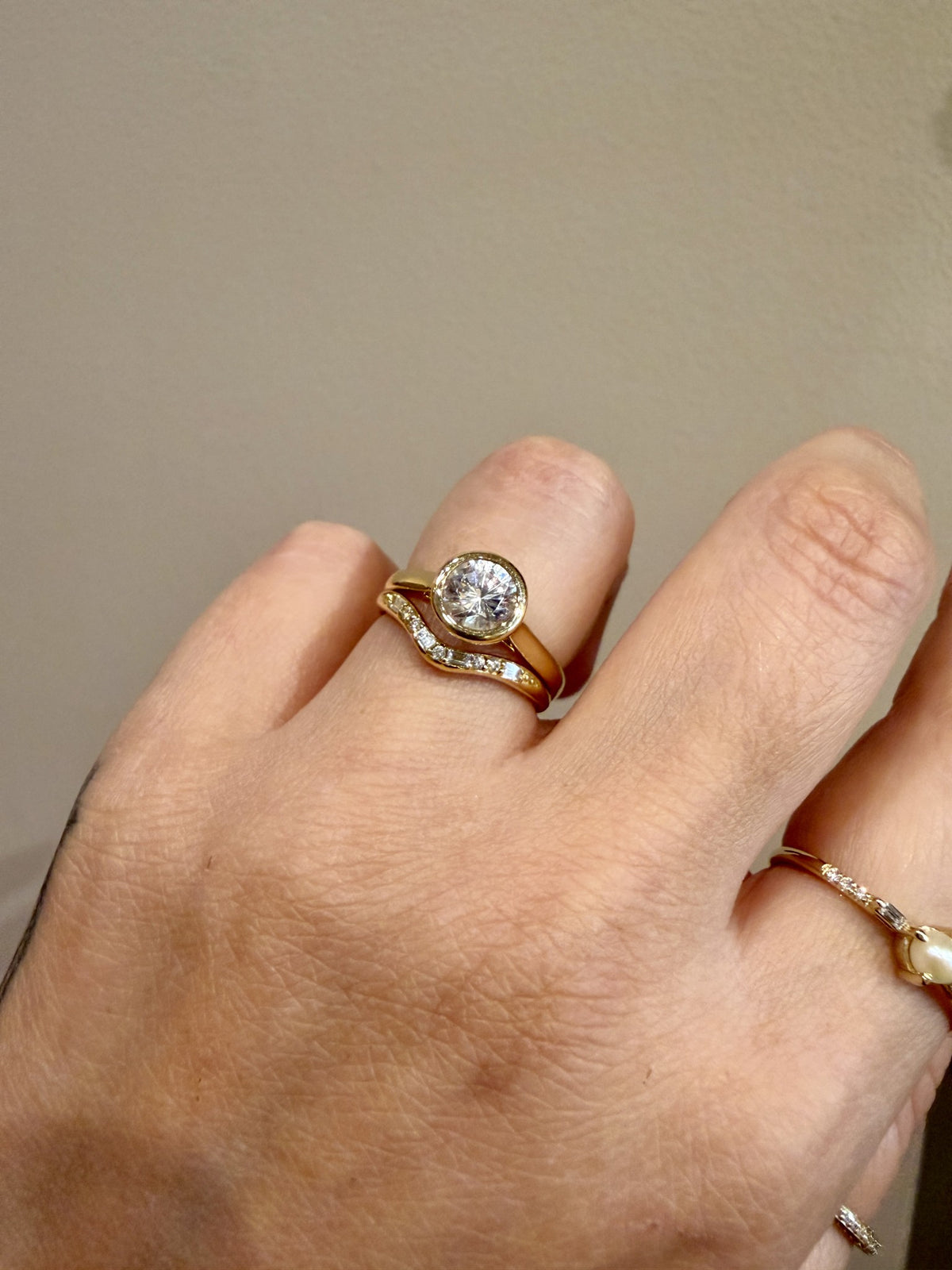 Jennie Kwon Diamond Staccato Wave Band with baguette and round diamonds in 14kt yellow gold paired with a bezel set round engagement ring