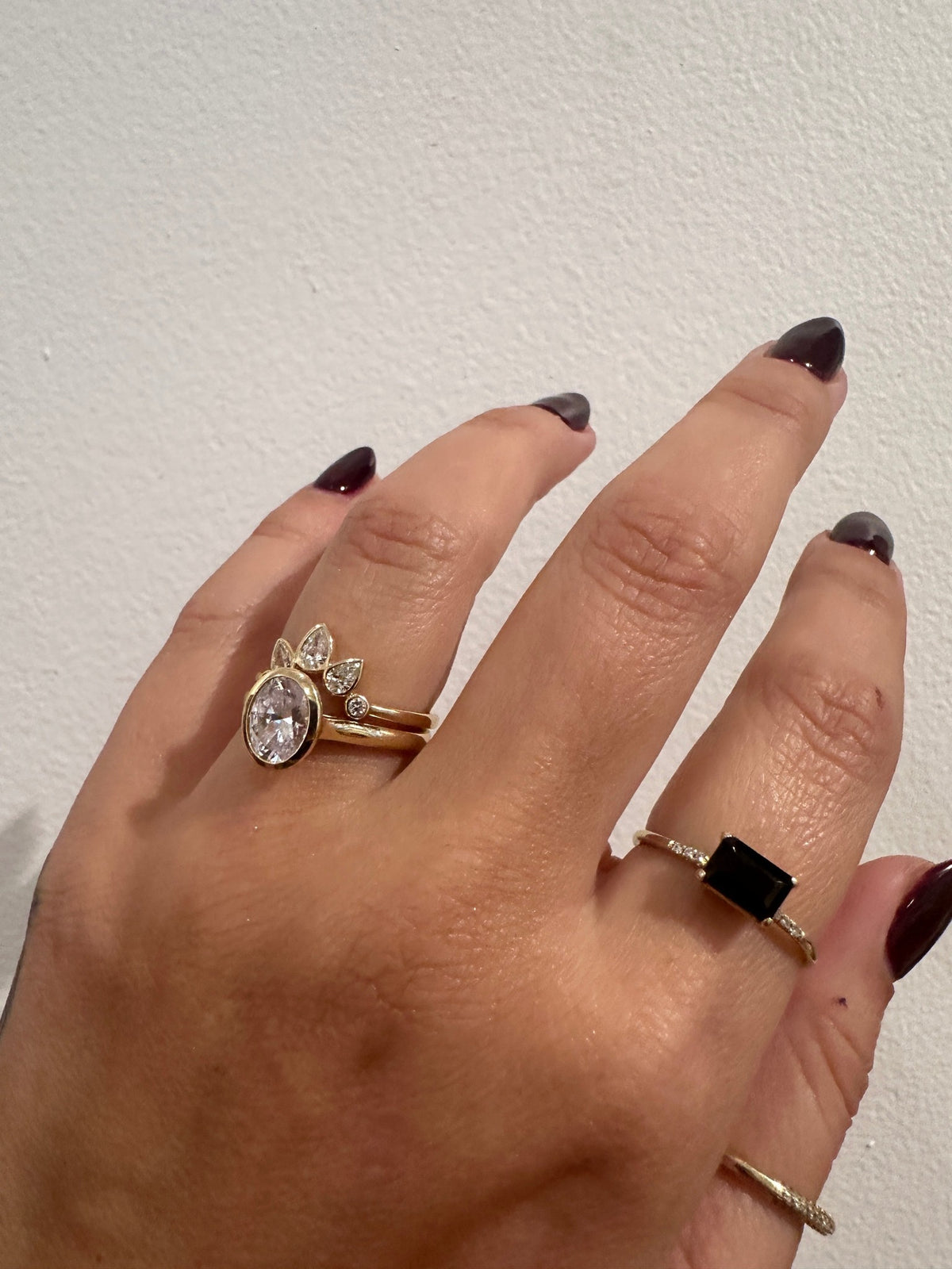 Bezel set pear diamond contour band stacked with an oval engagement ring