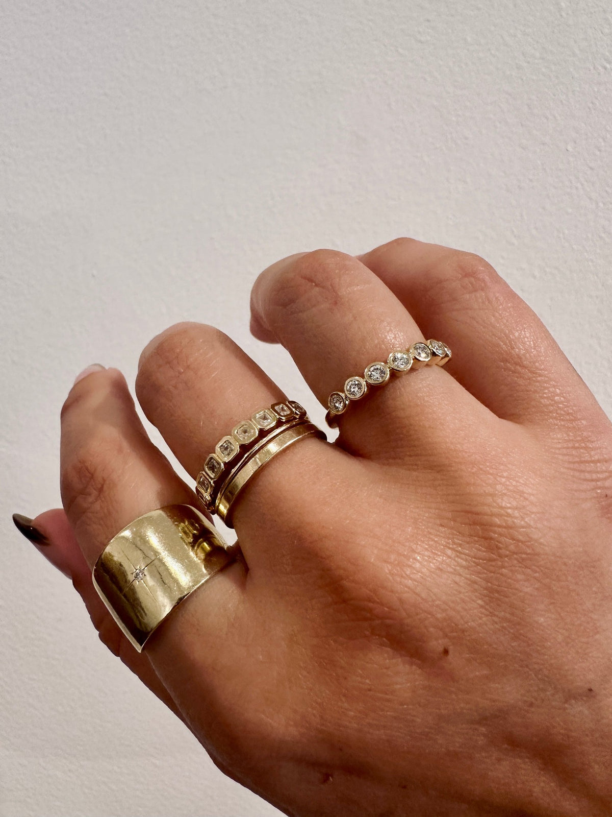 Diamond Deity wedding band in 14kt yellow gold with bezel set round diamonds worn on the hand