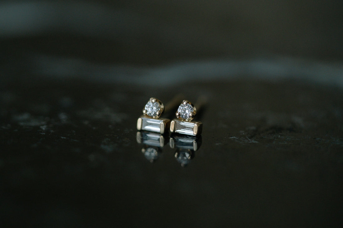 Zoe Chicco Baguette &amp; Prong Diamond Stacked Studs in 14kt yellow gold, a round diamond stacked on a baguette, on dark stone