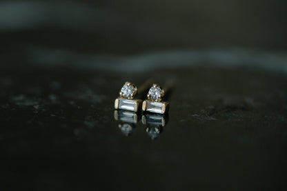Zoe Chicco Baguette &amp; Prong Diamond Stacked Studs in 14kt yellow gold, a round diamond stacked on a baguette, on dark stone