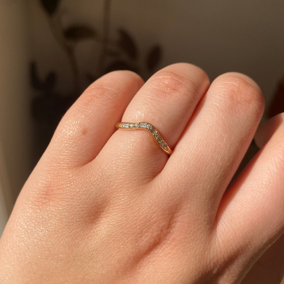 Jennie Kwon Diamond Staccato Wave Band with baguette and round diamonds in 14kt yellow gold, worn on the hand