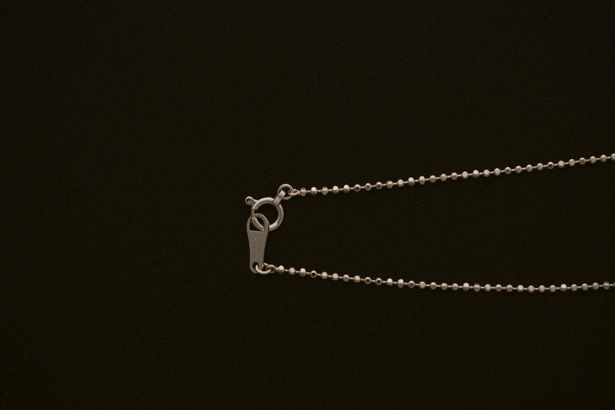BB Ball Chain in 10kt yellow gold with spring ring clasp on a dark background