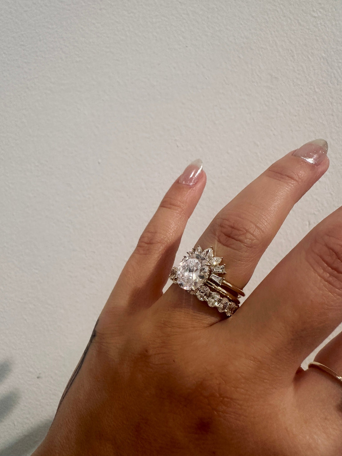 Starburst Diamond Deco Wedding Band contoured around a round halo engagement ring on hand