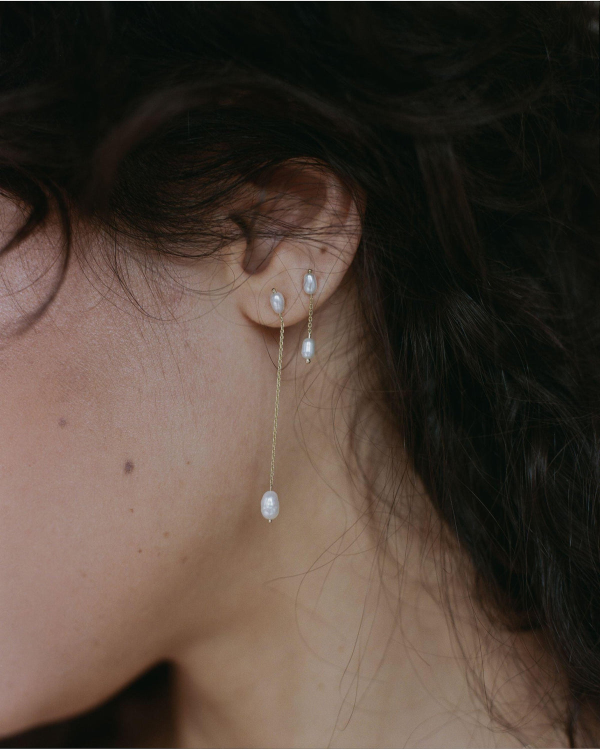 Pearl Shower Earrings worn on the ear, side view