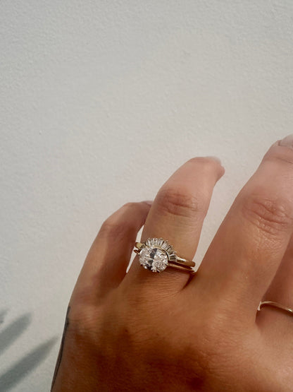 Baguette Rivers Contour Wedding Band with an oval engagement ring on hand