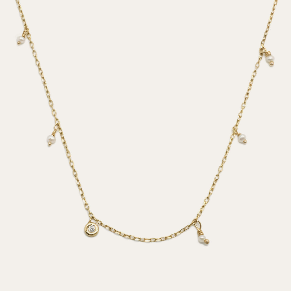 Pearl Shaker Necklace by Gjenmi, 14kt yellow gold diamond cut chain with freshwater pearls and a bezel set white diamond