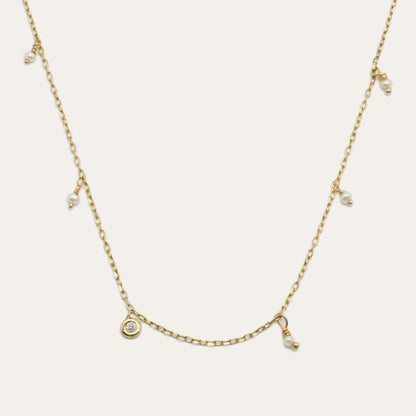 Pearl Shaker Necklace by Gjenmi, 14kt yellow gold diamond cut chain with freshwater pearls and a bezel set white diamond
